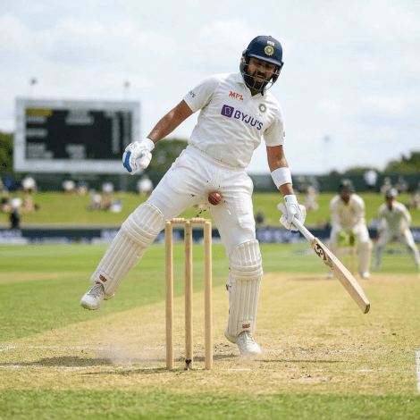 Cricket batsman diving forward to strike the ball near stumps